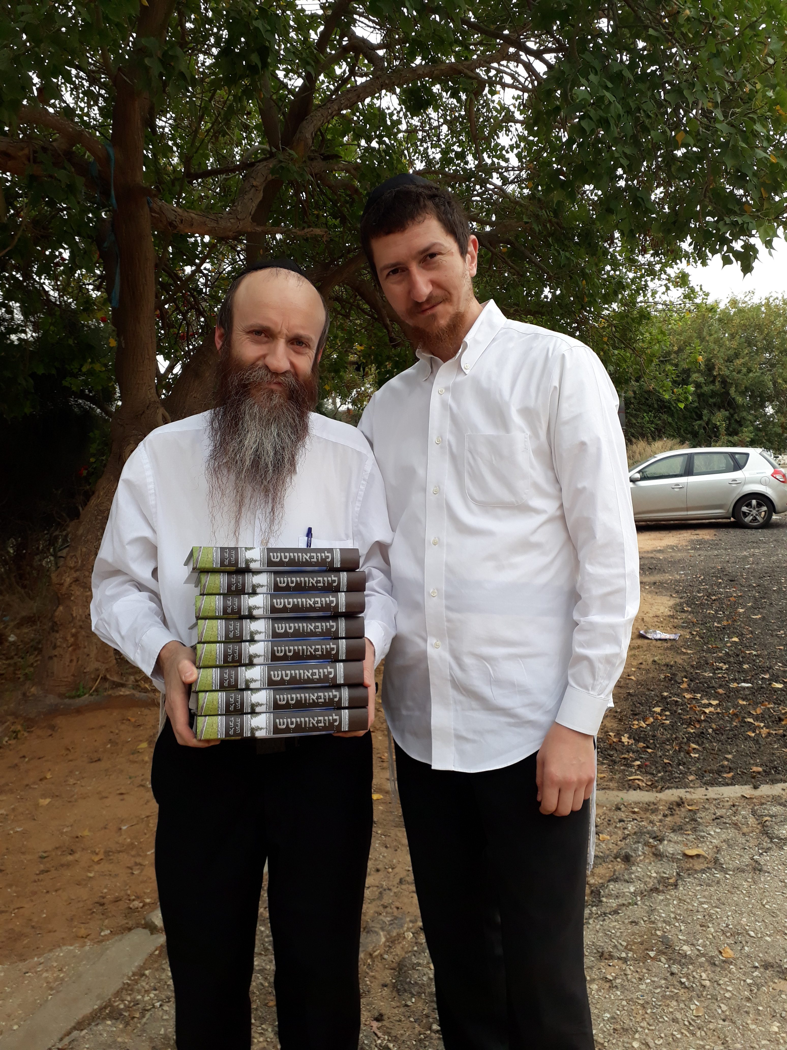 הרב אלישיב, עורך הספר, נושא ערימת ספרים בידו